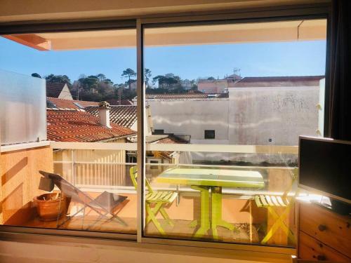 d'une fenêtre donnant sur un balcon avec une table. dans l'établissement Studio cosy à Arcachon, à 200 m de la plage et proche du centre, avec balcon ensoleillé. - FR-1-433-72, à Arcachon