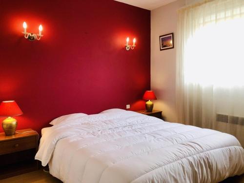une chambre avec un lit blanc avec un mur rouge dans l'établissement Arcachon : Appartement T2 avec balcon et parking, à deux pas des plages de l'Aiguillon - FR-1-433-66, à Arcachon