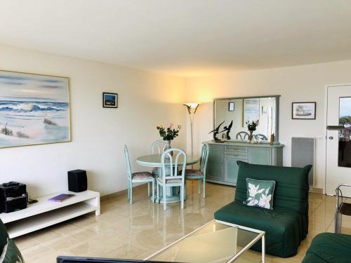 - un salon avec une table et un canapé vert dans l'établissement Arcachon : Appartement T2 avec balcon et parking, à deux pas des plages de l'Aiguillon - FR-1-433-66, à Arcachon