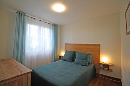 1 dormitorio con cama con sábanas azules y ventana en Le magnolia en Couzeix