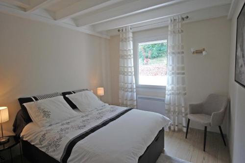 a bedroom with a bed and a window and a chair at L'escapade in Limoges