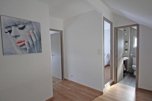 une chambre blanche avec une peinture d'une femme avec des produits cosmétiques dans l'établissement L'escapade, à Limoges