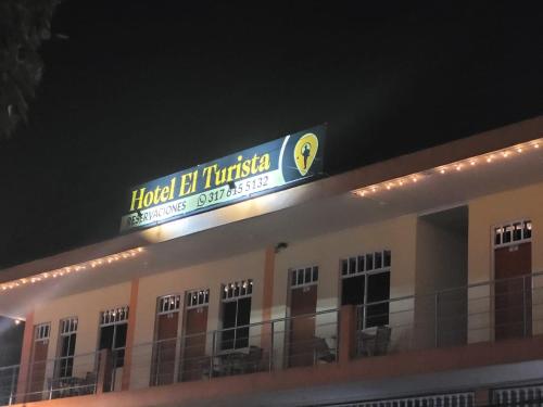 a sign on top of a building at night at Hotel el Turista in Florencia