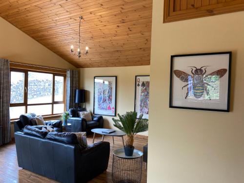 a living room with a couch and a butterfly on the wall at Copper Beech Lodge with Hot Tub in Cupar