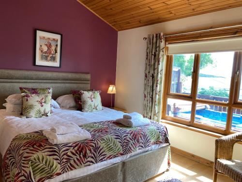 a bedroom with a bed with a large window at Copper Beech Lodge with Hot Tub in Cupar