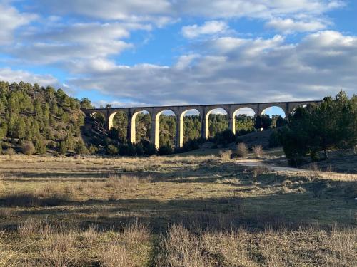 a viaduct over a field with a train on it at Casa Carrasquillas in Cañada del Hoyo