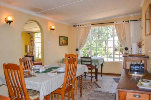 una cucina e una sala da pranzo con tavolo e sedie di Yellowwood Cottage a Himeville