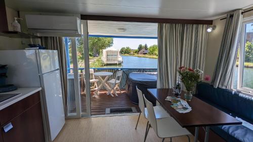 uma cozinha e sala de jantar com vista para um barco em Cottage flottant jacuzzi privé en option gamme supérieure em Saint-Jean-de-Losne