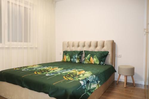 a bed with a green comforter with bananas on it at NEW Apartment J22, Free Private Parking, Terrace, Self Check-in in Kaunas