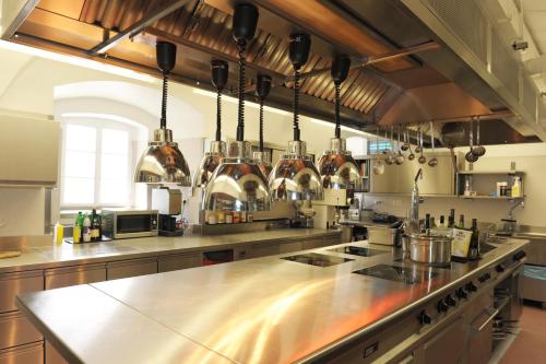 a large kitchen with a large stainless steel counter top at Schlosshotel Rosenau Superior in Schloss Rosenau
