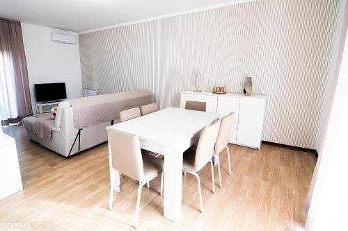 Cette chambre blanche dispose d'une table, de chaises et d'un lit. dans l'établissement Valmontone Travel Rooms (casa vacanze), à Valmontone
