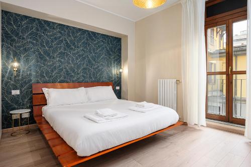 sypialnia z dużym łóżkiem z białą pościelą w obiekcie Italianway - Corso Como 12 w Mediolanie