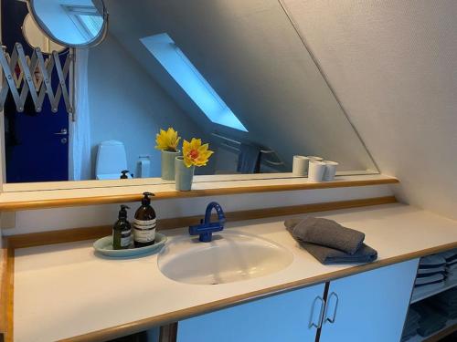 W łazience znajduje się umywalka, lustro i umywalka. w obiekcie Skønt hus på landet tæt på Billund w mieście Give