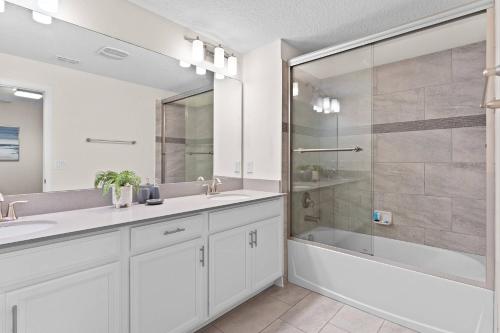 uma casa de banho branca com 2 lavatórios e um chuveiro em Gorgeous 5R Townhouse at Storey Lake SL4935 em Kissimmee