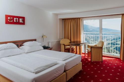 una camera d'albergo con un letto e una grande finestra di Hotel Friesacherhof a Prebl