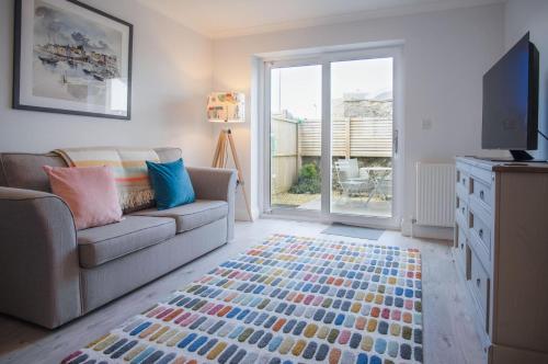 a living room with a couch and a tv at Ty Melyn - 2 Bedroom Cottage - Tenby in Tenby