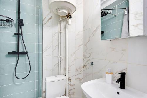 een badkamer met een douche, een toilet en een wastafel bij Magnifique 4 personnes Paris 18ème in Parijs