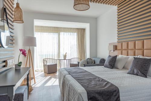 a bedroom with a large bed and a dining room at Piere - Anne Beach Hotel in Ayia Napa