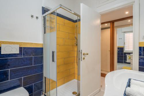 y baño con ducha de azulejos azules. en Daniela's Place, en Roma