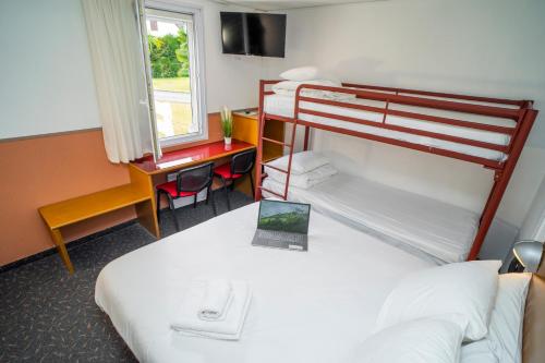 a hotel room with two bunk beds and a desk at Quick Palace Pau Zénith in Pau