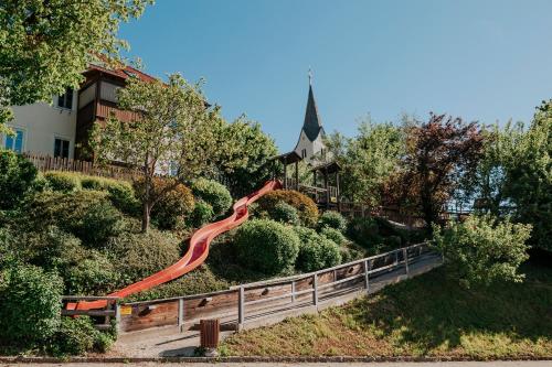 an orange slide on a hill in front of a house at Hotel Friesacherhof in Prebl