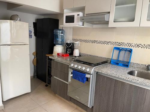 a kitchen with a stove and a white refrigerator at Casa de tus Sueños Dream Lagoons Veracruz in Veracruz