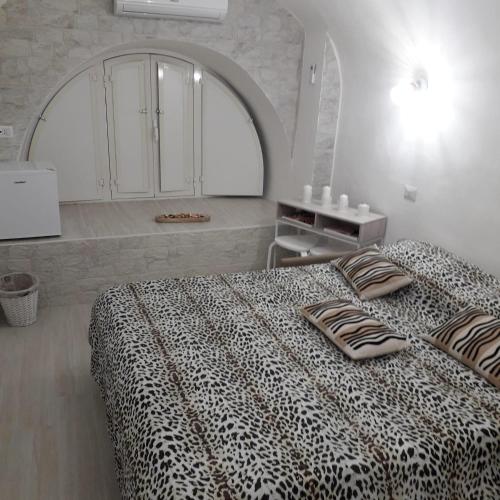 um quarto com uma cama com um cobertor de leopardo em La petite Maison Bari em Bari