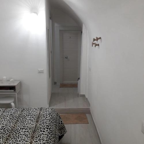 um quarto branco com uma cama e um corredor em La petite Maison Bari em Bari