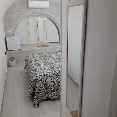 um quarto com uma mesa e um espelho num quarto em La petite Maison Bari em Bari
