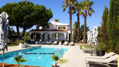 eine Villa mit einem Pool und Palmen in der Unterkunft Casa Bela Moura, Boutique Hotel & Wine in Porches