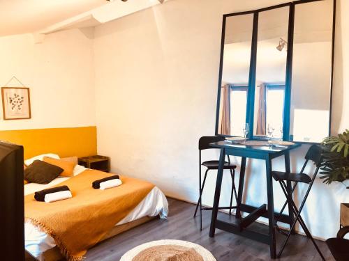 um quarto com uma cama e uma mesa com um espelho em CASA AMARILLA Avec Exterieur em Nîmes