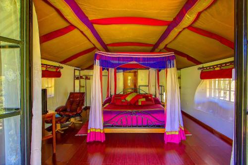 a bedroom with a canopy bed in a bus at Poa Place Resort & Hotel - Where Nature Meets Comfort Eldoret in Eldoret