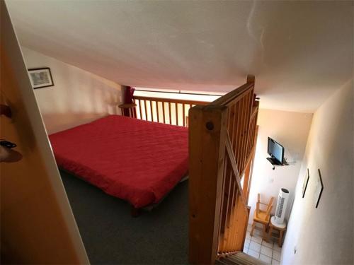 - une chambre avec un lit rouge et un escalier dans l'établissement Charmante Villa T1+Cabine+Mezzanine – 4 pers, Terrasse, Parking, Proximité Commerces, Bord de Lac - FR-1-81-53, à Port-Leucate