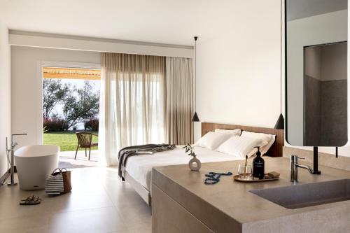 - une chambre avec un lit, une télévision et une salle de bains dans l'établissement Armacera Resort, à Zambrone