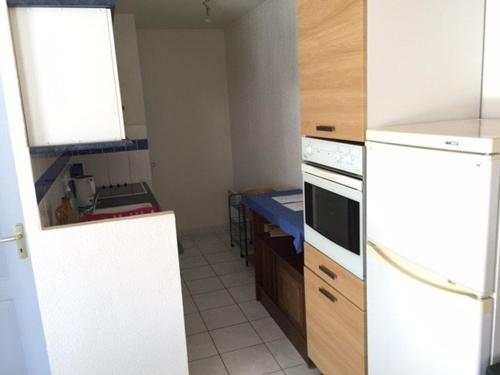 une cuisine avec des armoires blanches et un four à plaques de cuisson dans l'établissement Villa T3 avec Terrasse, 6 Couchages, Proche Port Leucate - FR-1-81-111, à Port-Leucate