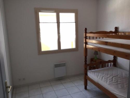 une chambre avec un lit superposé et une fenêtre dans l'établissement Villa T3 avec Terrasse, 6 Couchages, Proche Port Leucate - FR-1-81-111, à Port-Leucate