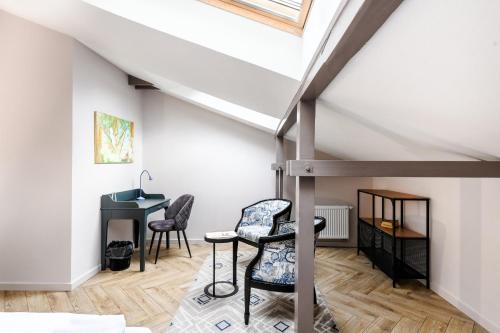 Zimmer mit einem Schreibtisch und Stühlen im Dachgeschoss in der Unterkunft Adler Aparthotel in Klaipėda