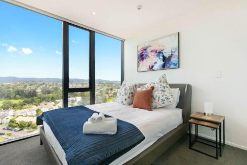 sypialnia z łóżkiem i dużym oknem w obiekcie Valley View Apartment with Mountain Views & Wi-Fi w Auckland