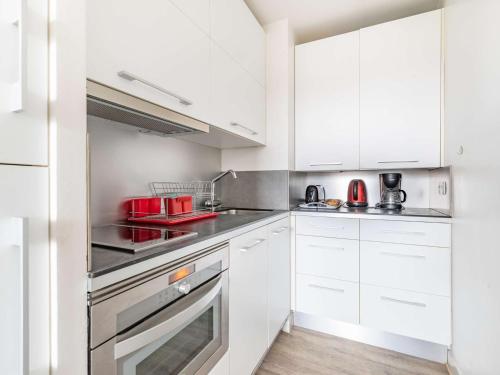 a kitchen with white cabinets and a red appliance at Studio Hendaye, 1 pièce, 3 personnes - FR-1-2-304 in Hendaye