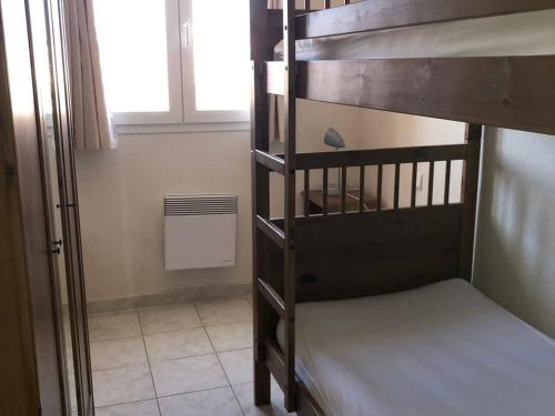Ce lit superposé se trouve dans un dortoir doté d'une fenêtre. dans l'établissement Villa T4 avec Piscine, 3 chambres, jardin, parking privé, proche commerces et plage, 8 couchages - FR-1-81-296, au Barcarès