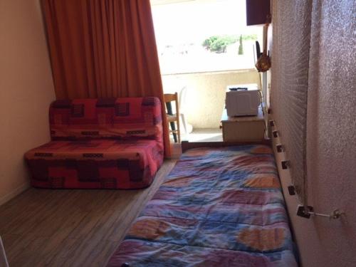 een kamer met een bed, een bank en een tapijt bij Studio Port Leucate, 1 pièce, 2 personnes - FR-1-81-352 in Port Leucate