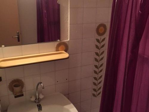 een badkamer met een wastafel, een spiegel en een douchegordijn bij Studio Port Leucate, 1 pièce, 2 personnes - FR-1-81-352 in Port Leucate
