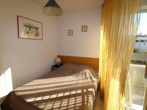 a small bedroom with a bed and a window at Appartement Le Grau-du-Roi, 2 pièces, 4 personnes - FR-1-307-10 in Le Grau-du-Roi