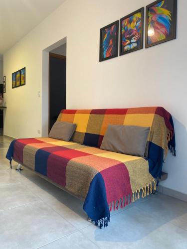 a bed in a room with a colorful blanket on it at Ap no centro piscina e churras in Ubatuba
