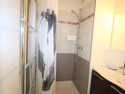 La salle de bains est pourvue d'une douche et d'une cravate sur le mur. dans l'établissement Studio Cabine 4 pers RDC avec Piscines, Terrasse, Proche Mer et Commerces - FR-1-307-36, au Grau-du-Roi