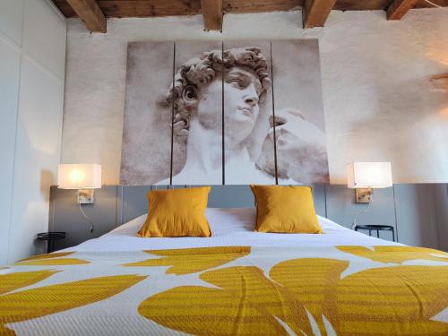a bedroom with a large bed with yellow pillows at Maison Egalité in Melay