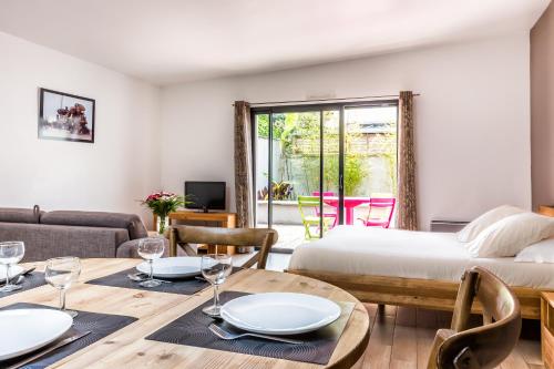 a bedroom with a bed and a dining room with a table at Résid'Spa Loire & Sèvre in Rezé