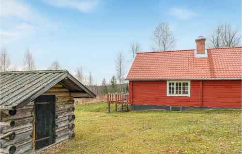 a red barn and a building with a red roof at Nice Home In Kopparberg With Sauna, 5 Bedrooms And Wifi in Ställdalen
