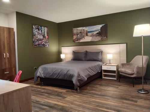 a bedroom with green walls and a bed and a chair at Hotel Boutique Quinta Camacho in Bogotá