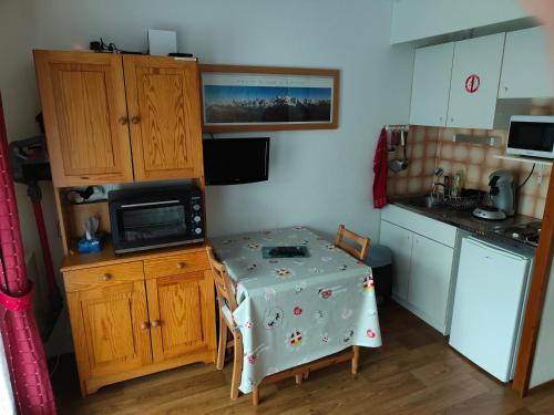 a kitchen with a table with a table cloth on it at Studio Les Contamines Montjoie - Les Combettes - Le Lay - WIFI INCLUS in Les Contamines-Montjoie